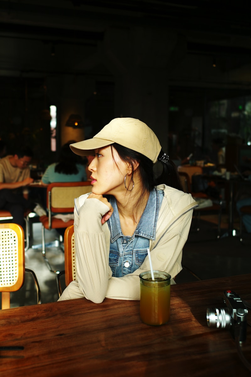 A woman sitting at a table with a drink in front of her