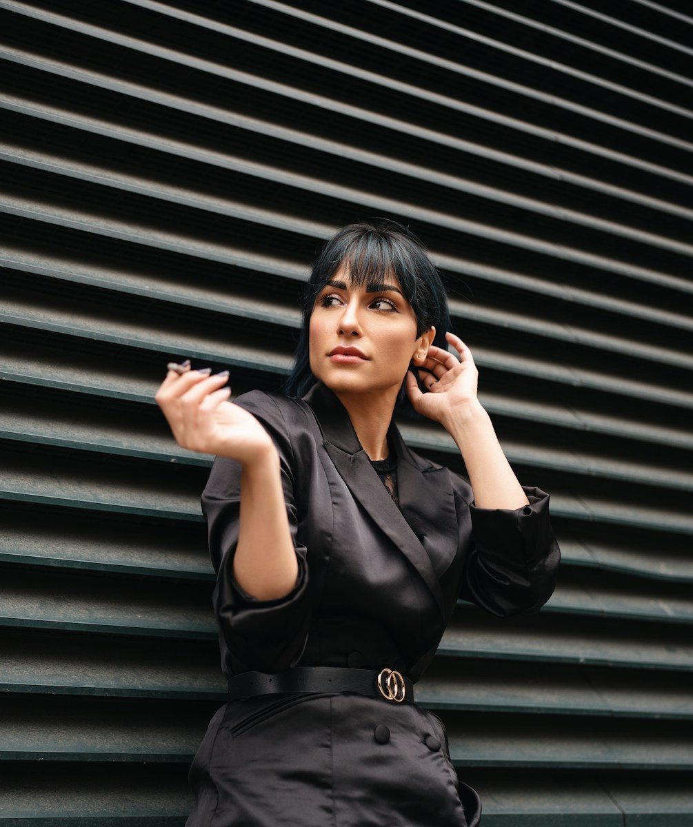 A woman leaning against a wall talking on a cell phone